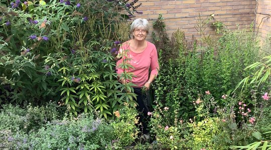 Inwoner Myra staat in groene tuin